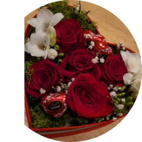 Scatola a forma di cuore con rose rosse e cioccolatini